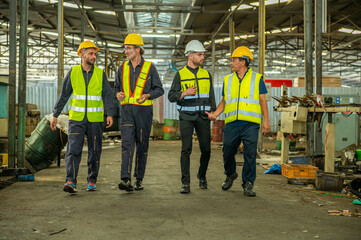 Group of engineer foreman walk line of troops straight in and talk together at end time of work in old Factory. unity teamwork colleague foreman and trainee walk straight in and talk collaboration.
