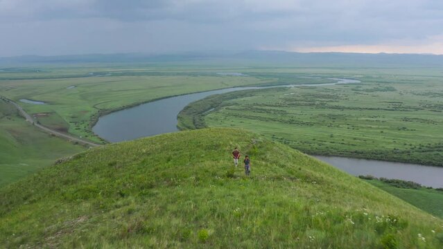 People Trekking On A Hill Overlooking Argun River In China On China-Russia Border. aerial pullback