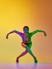 Fototapeta na wymiar Artistic, talented young woman in underwear dancing contemp against gradient yellow orange background in neon light. Concept of modern dance style, hobby, art, performance, lifestyle, ad