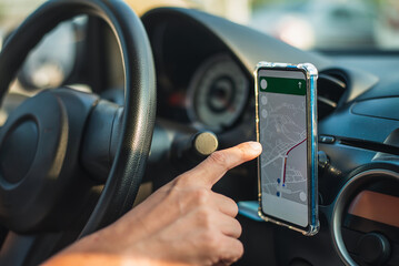 Man driving while using the mapping app on his smartphone to find his location. using a phone as a navigation device in a car