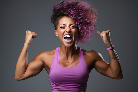 female athlete flexing her muscles while smiling 