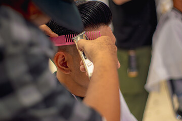 Close-up professional hairdresser using scissors and clippers and accessories for beautiful and decorating men hair Cutting hair for male customer, barbershop fashion and beauty hipster style concept