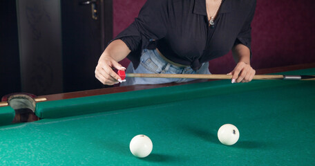 Fototapeta premium Caucasian young girl playing billiards.