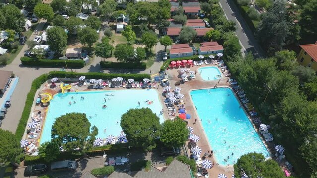 Aerial Shot Orbiting Swimming Pool with People in Camping Cisano San Vito at Lake Garda, Italy