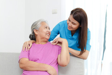Fototapeta premium Physiotherapist with elderly female patient sitting on sofa in treatment room. Doctors and seniors. Physical therapy in the health center