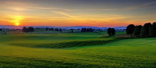 Fototapeta premium Magical Sunset Over Green Meadows Landscape For Background