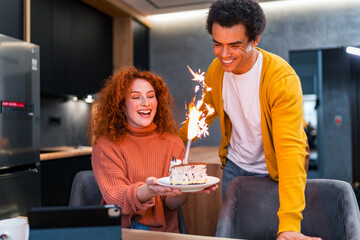 A red-haired girl is surprised by a cake that her boyfriend brought her as a birthday surprise. She is very happy and excited