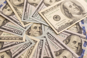 Many hundred dollar bills on wooden table background texture. bundles of money scattered on the office desk. wealth and income concept