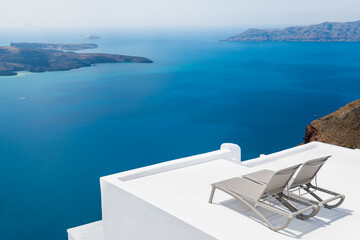 White architecture in Santorini island, Greece. Chaise lounges on the terrace with sea view.