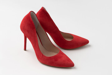 Elegant women's summer suede red stilettos. A new pair of shoes on a white background.