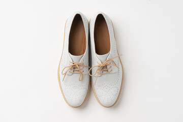 Casual white mid-season leather shoes with white laces and cork soles. New women's shoes on a white...