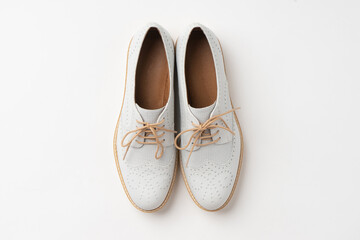 Casual white mid-season leather shoes with white laces and cork soles. New women's shoes on a white background.