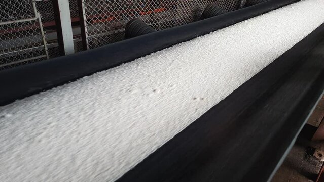 Mineral fertilizers are transported by conveyor belt on chemical plant.