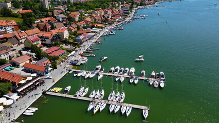 Panoramic aerial photo from drone to Mikolajki townscape - capital of Masurian region on the shore of the holiday resort beautiful summer afternoon. Mikolajki, Mikołajki, Poland, Europe.