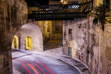 the empty streets of Valletta at night. Street lights illuminate the old houses