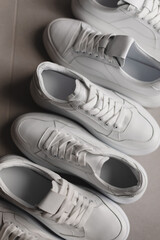 Close up details of white sneakers on the floor. Casual fashion style minimalistic shoes.
