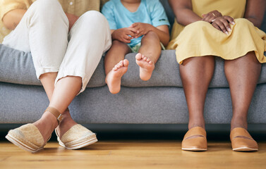Legs, gay couple and a family on a home sofa for security, quality time and love. Feet of women or lesbian parents and a young child together in a living room with trust, care or support for adoption