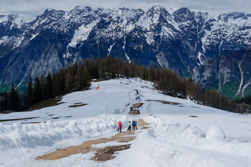 colorful hikers on a path with snow and a huge mountain range in upper austria