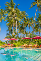 Beachside tourism landscape. Luxurious beach resort poolside. Infinity swimming pool beach chairs or loungers, umbrellas with relaxing palm trees and blue sky. Summer leisure travel panoramic vacation