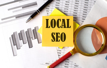 LOCAL SEO text on a sticky on the graph background with pen and magnifier