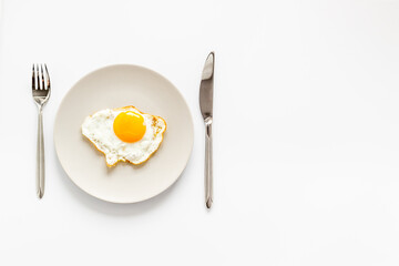 Fried egg on white plate, top view. Food background