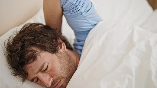 Young hispanic man lying on bed stressed at bedroom