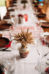 wedding decor in rustic style, flowers and ears of corn in vases