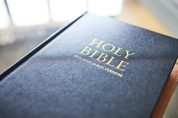 Closeup, bible book and home for faith, studying religion and mindfulness with holy spiritual...