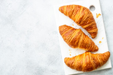 Fresh Croissants on white table. French bakery. Top view with space for text.