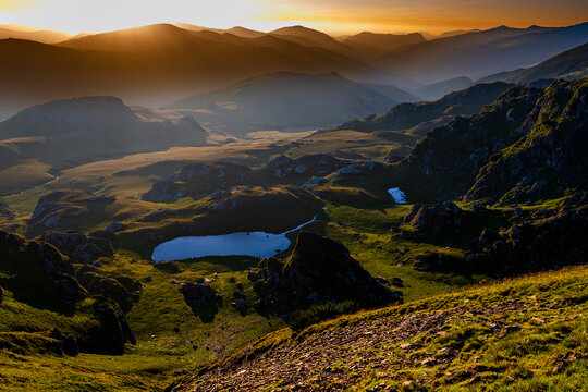 Mountain landscape with the rising sun. Dark background with a copy space. The Parang Mountains, Romania.