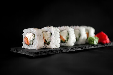 Set of rolls with tuna and cream cheese on a black background