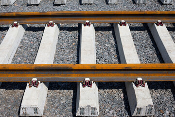 Rusty rails and concrete sleepers, railway track for trams and trains close photo across frame