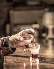 Man shots cocktail. Tequila shots, vodka,whisky, rum. Barman in pub. Tequila shot. Colorful...