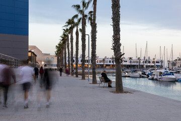 Menschen auf der Promenade am Hafen in Alicante am Abend zur blauen Stunde