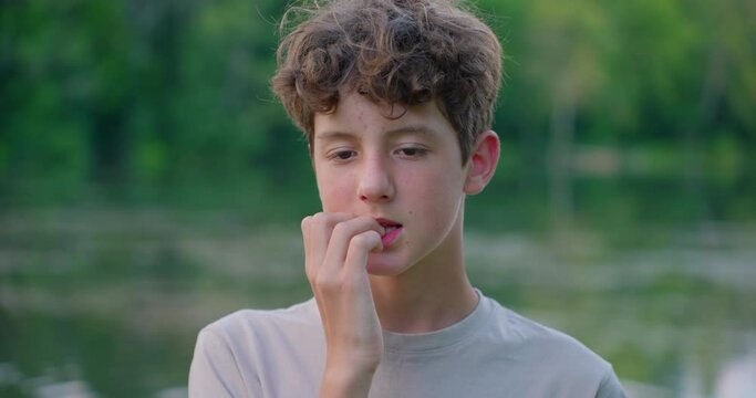 Close-up youth teenager biting nails. Adolescent problems
