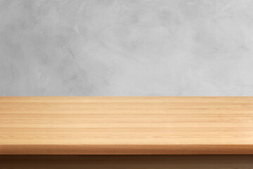 A beautiful wooden table with a cement wall in the background.
