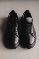 Close up details of black sneakers on the floor. Casual fashion style minimalistic shoes.