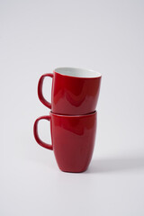 red ceramic coffee mugs on a white background