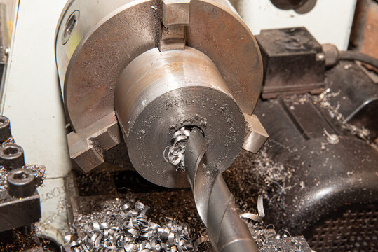 Drilling on a lathe, drilling a work piece held in a three-jaw chuck. Machining, turning metal.