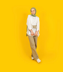 Muslim woman, full body front view young caucasian muslim woman. Young girl holding closed laptop...