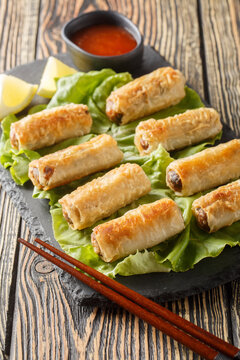 Cha gio or nem ran or fried spring roll, is a popular dish in Vietnamese cuisine closeup on the plate on the table. Vertical