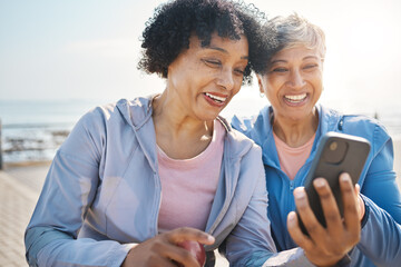 Senior women, phone and social media in nature for a chat, notification or a funny meme. Happy, reading online and elderly friends by the sea with a mobile app for communication or internet memory