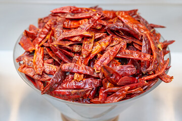 Pile of dried red chili pepper in the bowl at the traditional spice market in Dubai