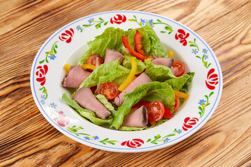 salad with ham on the wooden background