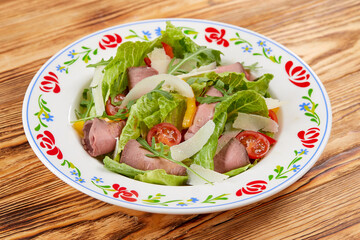 salad with ham on the wooden background