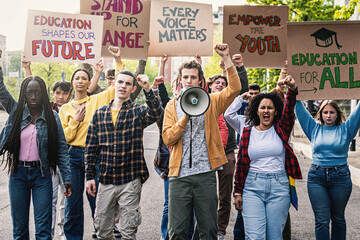 Multiracial Students Protesting for Education - Diverse group of young students marching, raising...