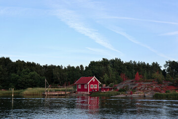 red wooden hut in a forest in Sweden by a lake. Peace in nature and ideal place for vacation