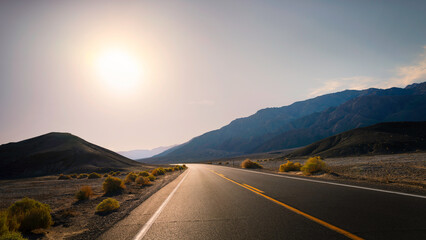 Sunrise on the road in Death Valley National Park in California. Hot dry desert climate in summer. - obrazy, fototapety, plakaty