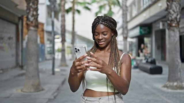 African american woman make selfie by smartphone smiling at street