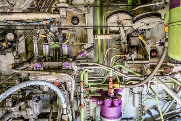 Detailed image of various pipes, hoses, tubes from the inside of an airplane. Hydraulic lines, valves, tubes, switches and wires in colourful arrangement.